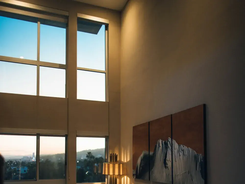 Warm Los Angeles living room at dusk with hillside views and cozy lamp light
